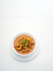 Panang chicken curry in white bowl.