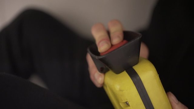 Scared guy hiding while pressing red button to make explosives explode, closeup, terrorist