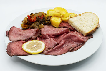 Slice Roast beef with potato and zucchini on white dish