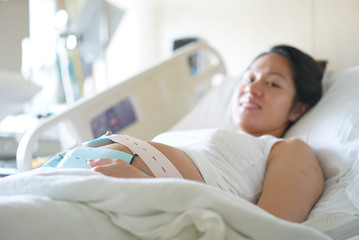 Pregnant Asian Chinese Woman lying on the hospital bed