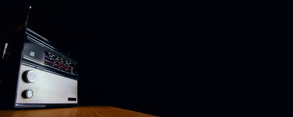 An old analog radio on a dark background. Space for text or design