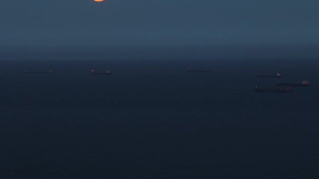 full moon raising from the sea between some ships.
Shot with canon 7d mark ii