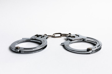 Handcuffs close-up on a white background. Selective focus. Blurred background