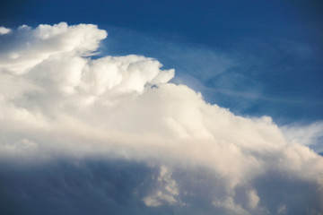 Obraz premium fluffy cottony white cloud over blue sky. painting like cloud image. chaotic cloud formation tapered to one side.