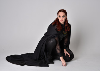 Fantasy portrait of a woman with red hair wearing dark leather assassin costume with long black...