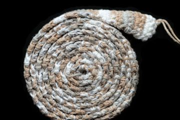 Crochet tape melange yarn rolled up on a black background close up. Top view. Handmade concept