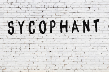 Word sycophant painted on white brick wall - obrazy, fototapety, plakaty
