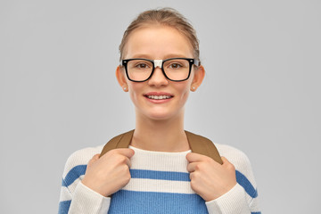education and people concept - happy smiling teenage student girl in glasses with school bag or...
