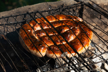 meat sausages on a barbecue rack. Picnic. Outdoor grill on a summer weekend.