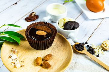 Chocolate Brownie Cake in Paper Cups Decorated with components for making cakes placed on wooden floors