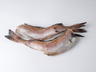 Frozen carcasses of pollock fish on a white background. Top view