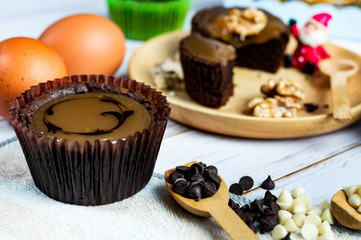 Chocolate Brownie Cake in Paper Cups Decorated with components for making cakes placed on wooden floors