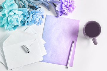 women's workplace, home office. flowers, a notepad and pen, and a coffee mug. creative gradient tinting . top view, copy space