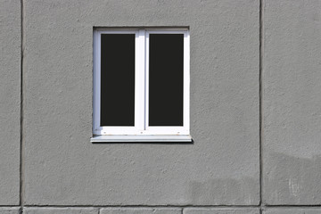 A double-hung window in the concrete slab of the new house. The texture of the concrete.