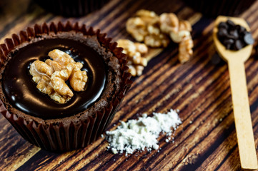 Chocolate Brownie Cake in Paper Cups Decorated with components for making cakes placed on wooden floors