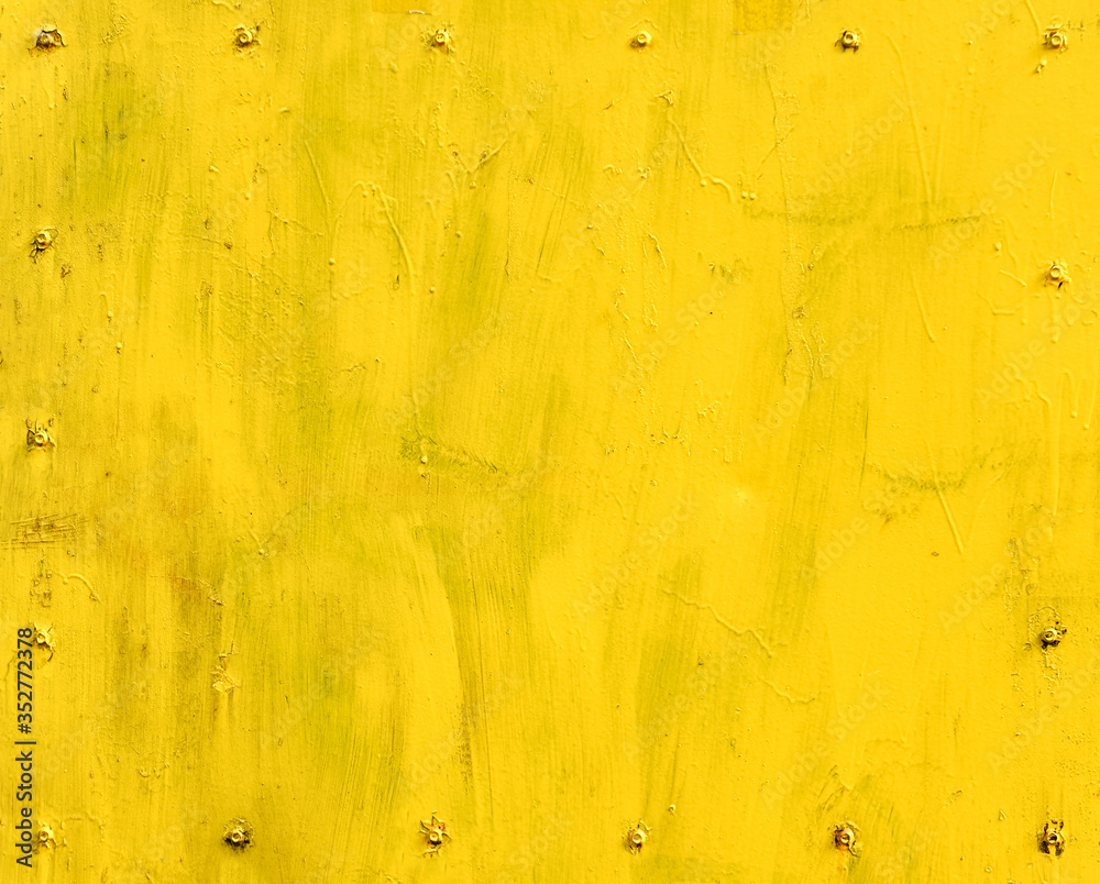 Wall mural yellow painted metal surface with screw fasteners