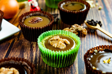 Chocolate Brownie Cake in Paper Cups Decorated with components for making cakes placed on wooden floors