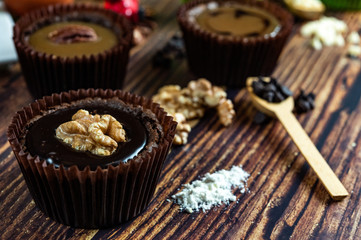 Chocolate Brownie Cake in Paper Cups Decorated with components for making cakes placed on wooden floors