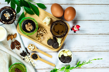 Chocolate Brownie Cake in Paper Cups Decorated with components for making cakes placed on wooden floors