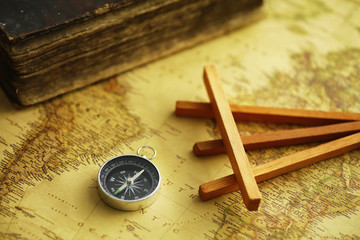 Travel and adventure search concept. Vintage aged map with a shabby book and compass. Shabby book and compass on the table.