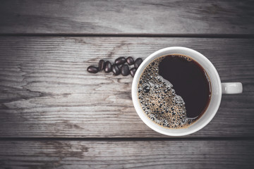 hot black coffee in the classic white luxury coffee cup set on a beautiful vintage dark old wooden table