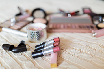Cosmetic products on beige knitted background. Beauty and makeup concept