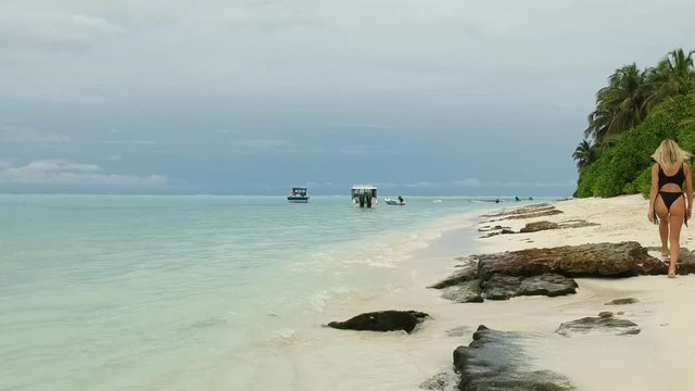young beautiful woman walking on the beach, Maldives,  thoddoo island.