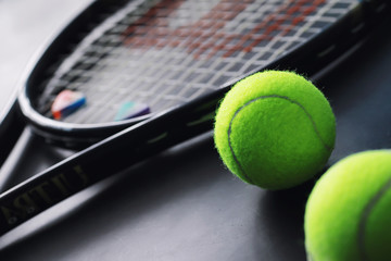 Sport and healthy lifestyle. Tennis. Yellow ball for tennis and a racket on the table. Sports background with tennis concept.