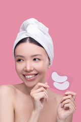 Smiling asian girl in a white headscarf having beauty procedures and feeling wonderful