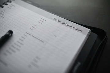 Filling out a form with personal information. Documents in a folder on the table to fill. Handwritten information about the applicant.