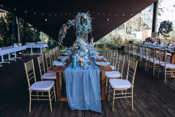 Banquet table setting and decoration. Cutlery on the table. Blue interior decoration.

