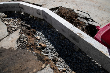 Setting road border before laying asphalt. Reconstruction of the sidewalk and replacement of old curbs. Road infrastructure repair