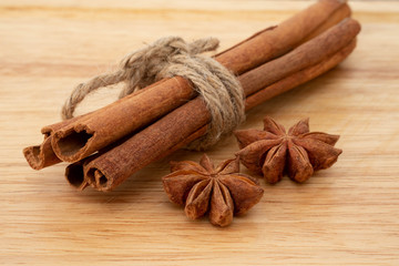 Star anise and cinnamon sticks on wooden background.