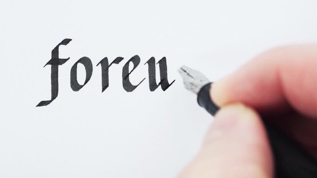 Writing of word Foreword. Hand writing with a pen. Calligraphy closeup.