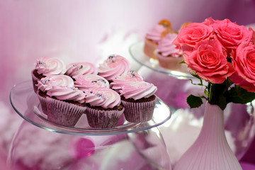 Table with pink cupcakes and different sweets for party. Candy bar.