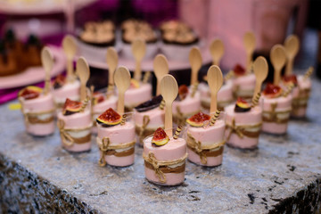 Candy bar. Table with sweets, candies, dessert. Pink dessert with mousse in a transparent dish.