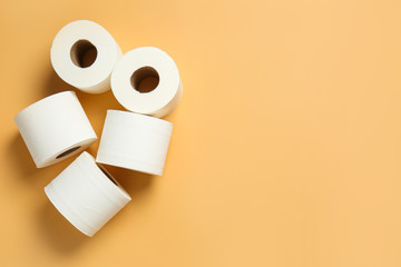 Rolls of toilet paper on color background