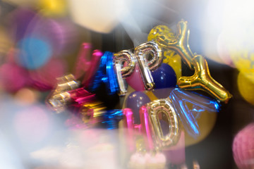 Colorful HAPPY BIRTHDAY words made of inflatable balloons on candy bar. Blur effect