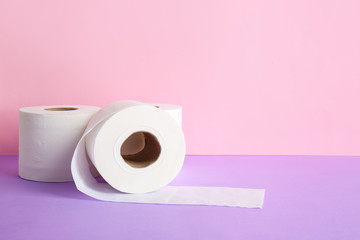 Rolls of toilet paper on color background