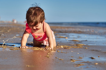 baby crying in the sand on the beach