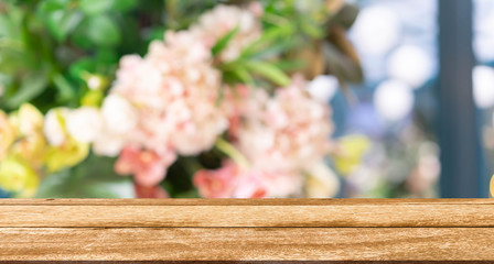 abstract blur tropical and spring flowers and floral background in beauty shop with brown wooden...