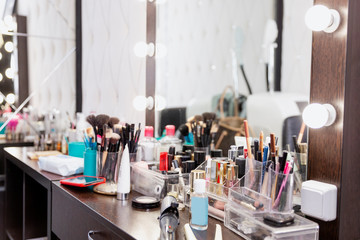 Dressing table in a beauty salon with lots of cosmetics.