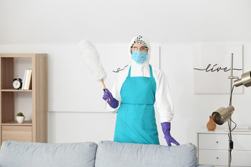 Housewife in protective costume cleaning room