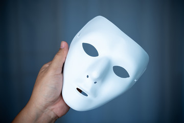 hand holding unidentified white mask