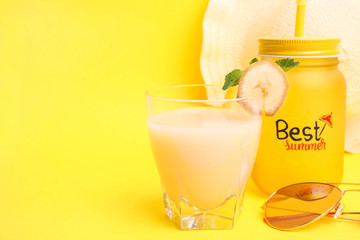 Banana juice in a jar and a glass with beach accessories