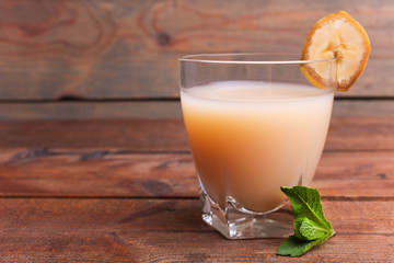 Banana juice in a glass with a slice of banana and mint