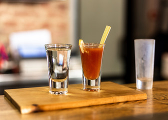 Cocktail in a glass with Tobasco and alcohol. Sambuca. A slice of lemon and celery. The interior of the bar.