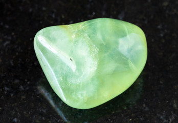 closeup of sample of natural mineral from geological collection - polished Prehnite rock on black...