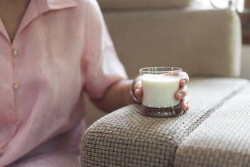 Senior asian woman hand holding a milk glass.