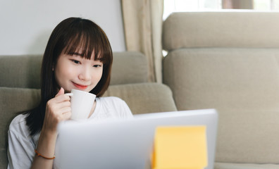 Asian teenager student woman learning via internet with laptop in new normal lifestyle.